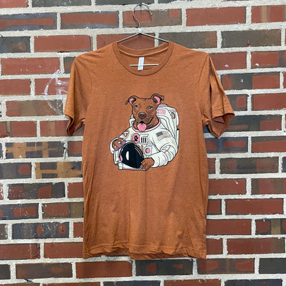 Pit bull mix dog dressed as astronaut design on warm heather brown t-shirt hanging against brick wall at Lowe Mill